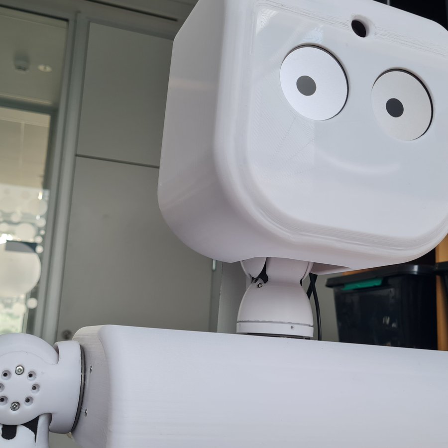 Das Bild zeigt den Kopf eines Roboters mit großen Augen und Mund