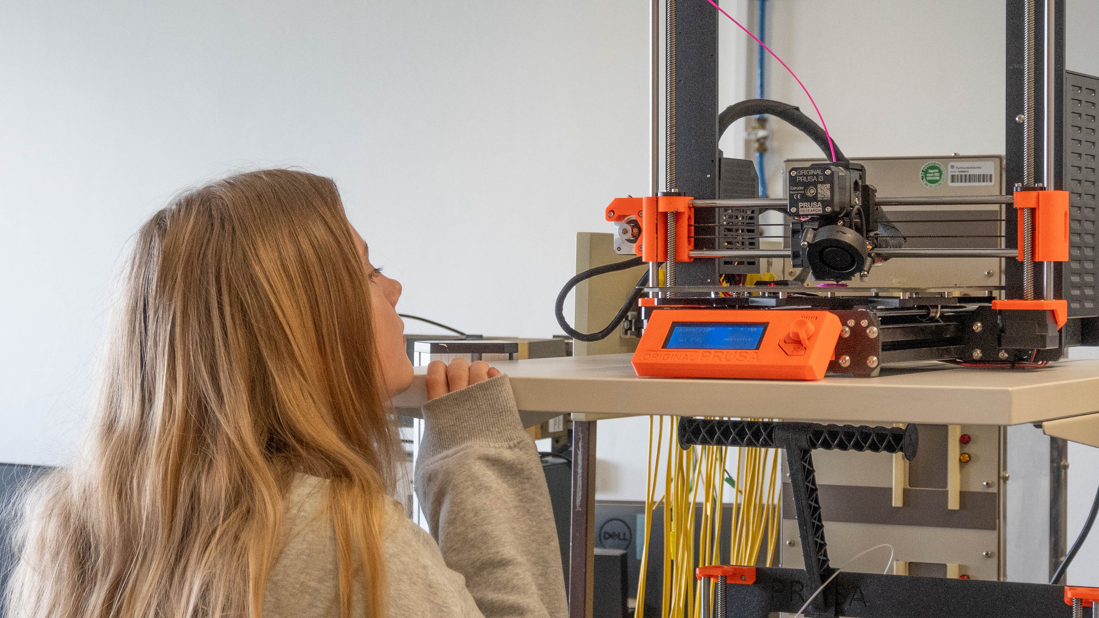 Ein Mädchen steht vor einem 3D-Drucker