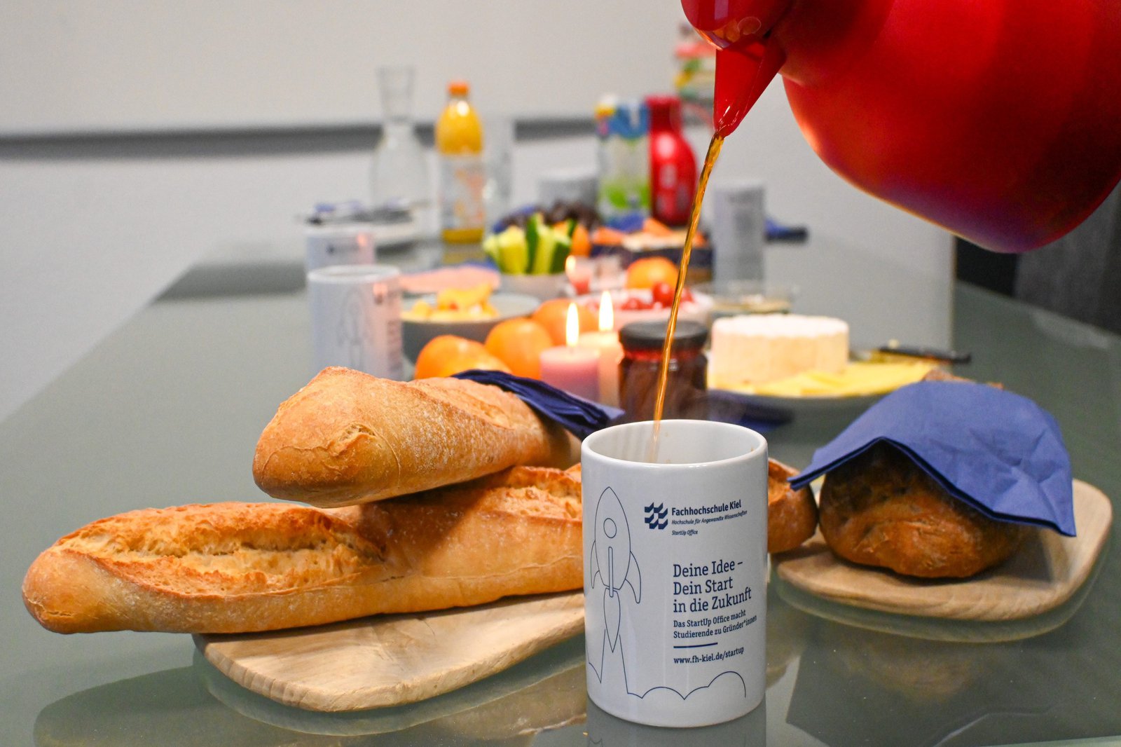 gedeckter Frühstückstisch mit StartUp Becher im Vordergrund im 