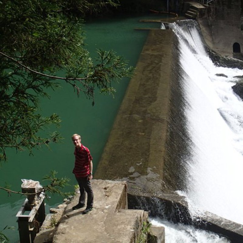 Ein Mann steht an einem Staudamm.
