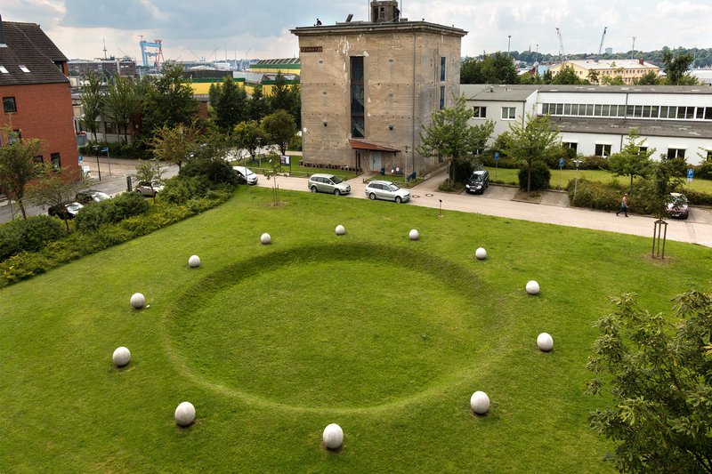 Kunstwerk welches einen Kreis gebildet aus Steinkugeln zeigt