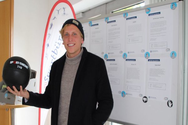 Timo Saager vor dem Sportbüro der Fachhochschule Kiel. Der 27-jährige arbeitet nun seit drei Jahren für das Hochschulsport-Team des AStA. Foto: Lennard Worobic 
