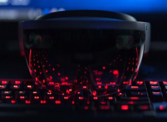 Eine VR-Brille liegt auf einer rot leuchtenden Tastatur.