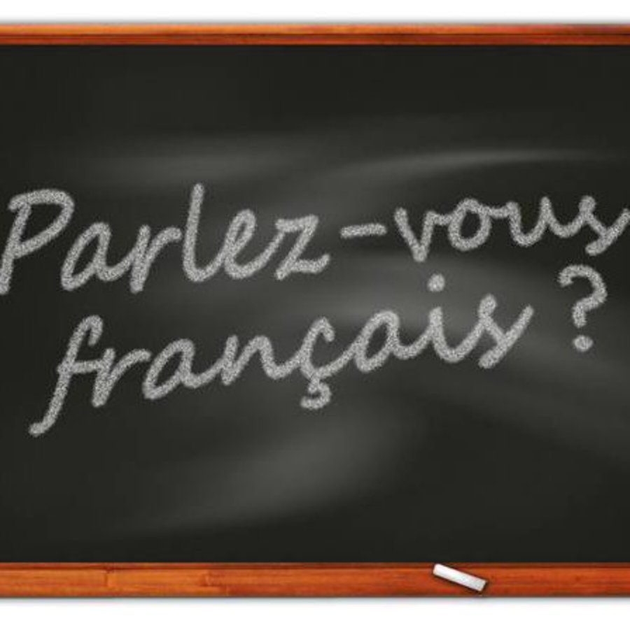 Die Grafik zeigt eine Tafel auf die mit Kreide "Parlez vous francais?" geschrieben wurde.