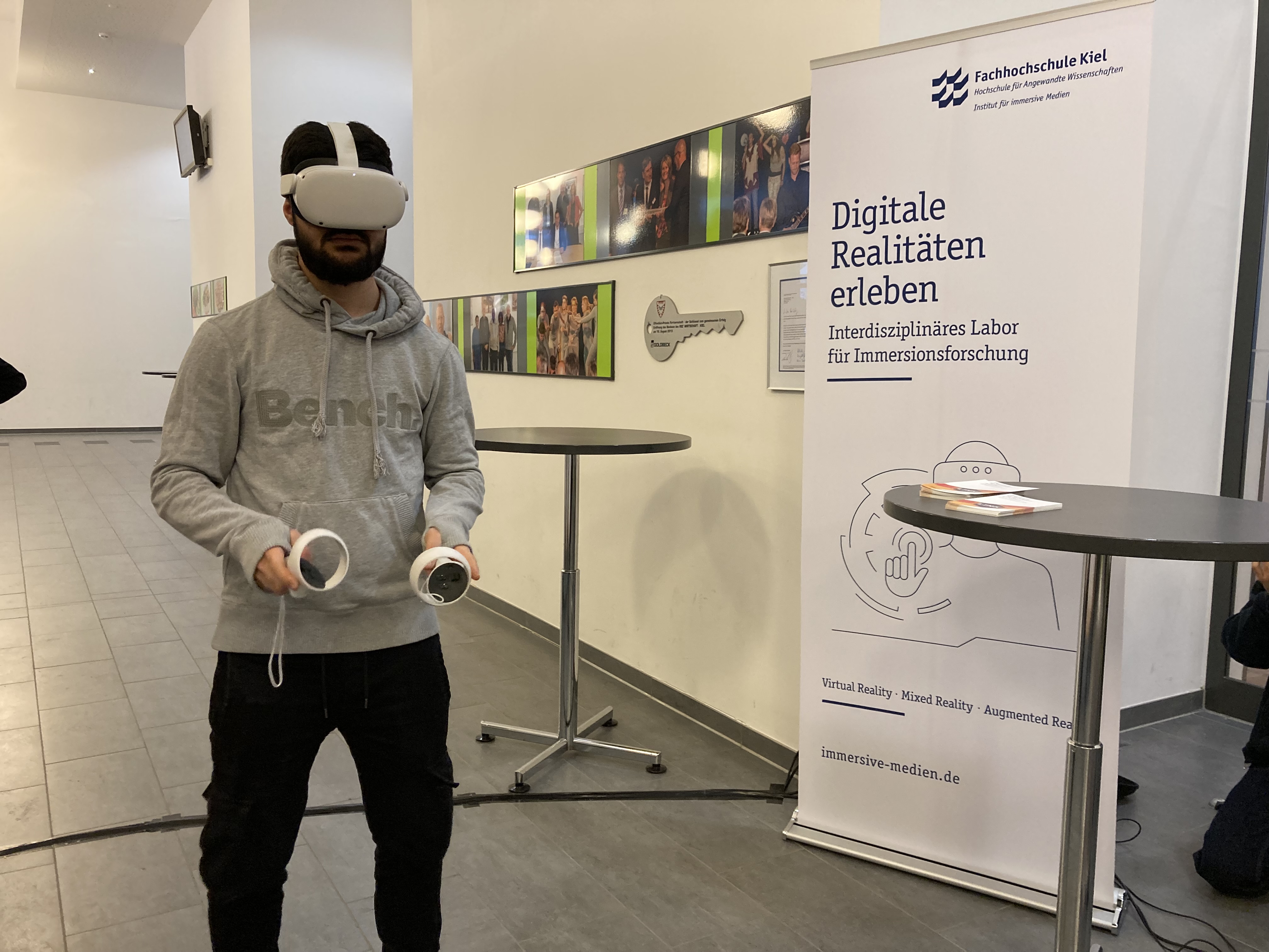 Ein Schüler trägt eine VR-Brille und zwei Controller