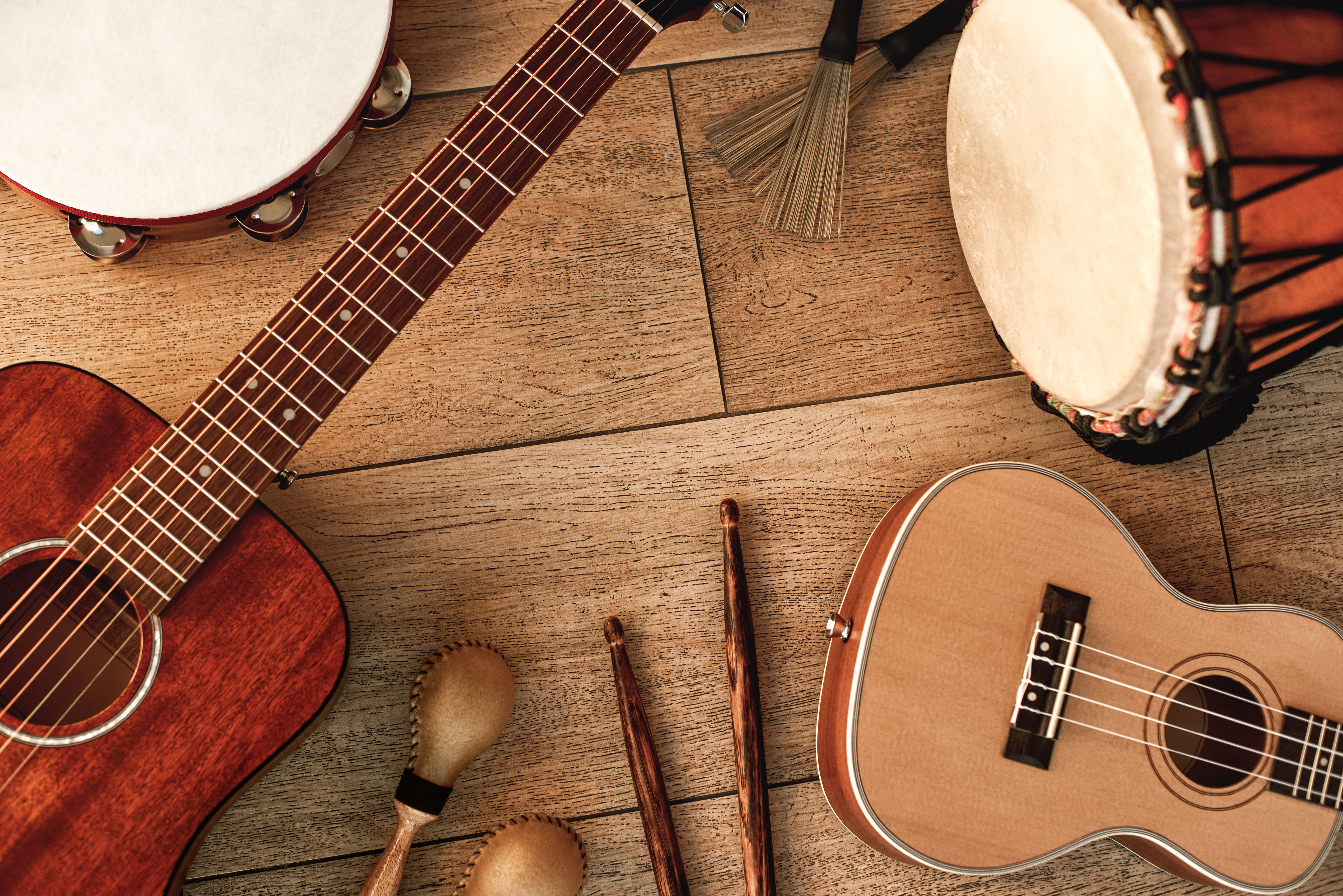 Blick von oben auf eine Schelle, eine Trommel, eine Okulele und eine Gitarre