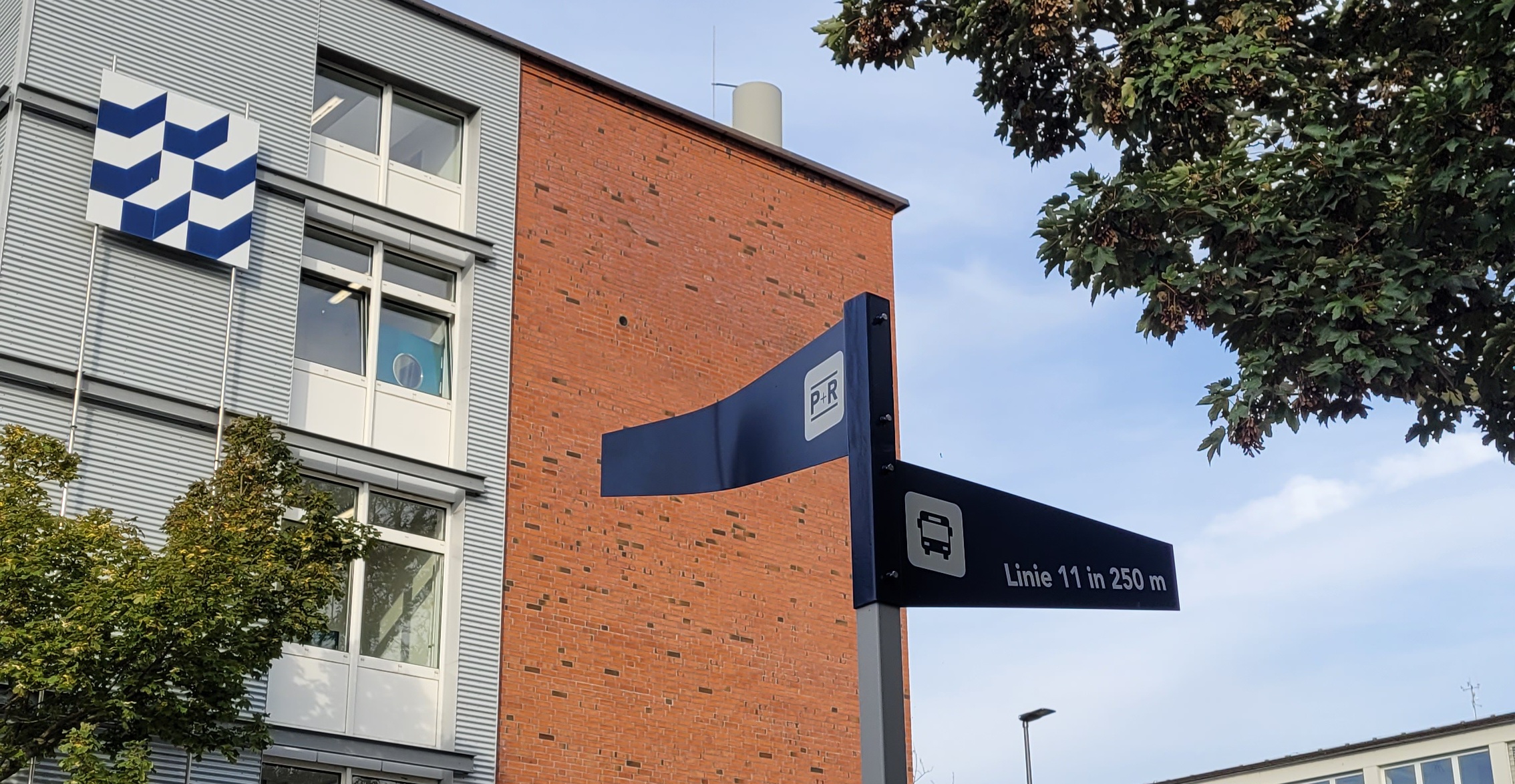 Ein Wegweiser-Schild vor einem Gebäude