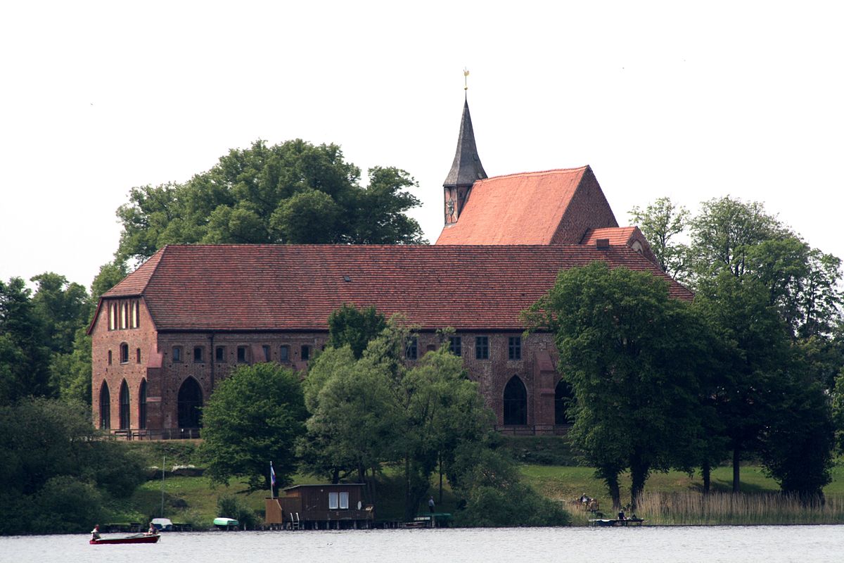 Ein Backstein-Kloster umgeben von Bäumen