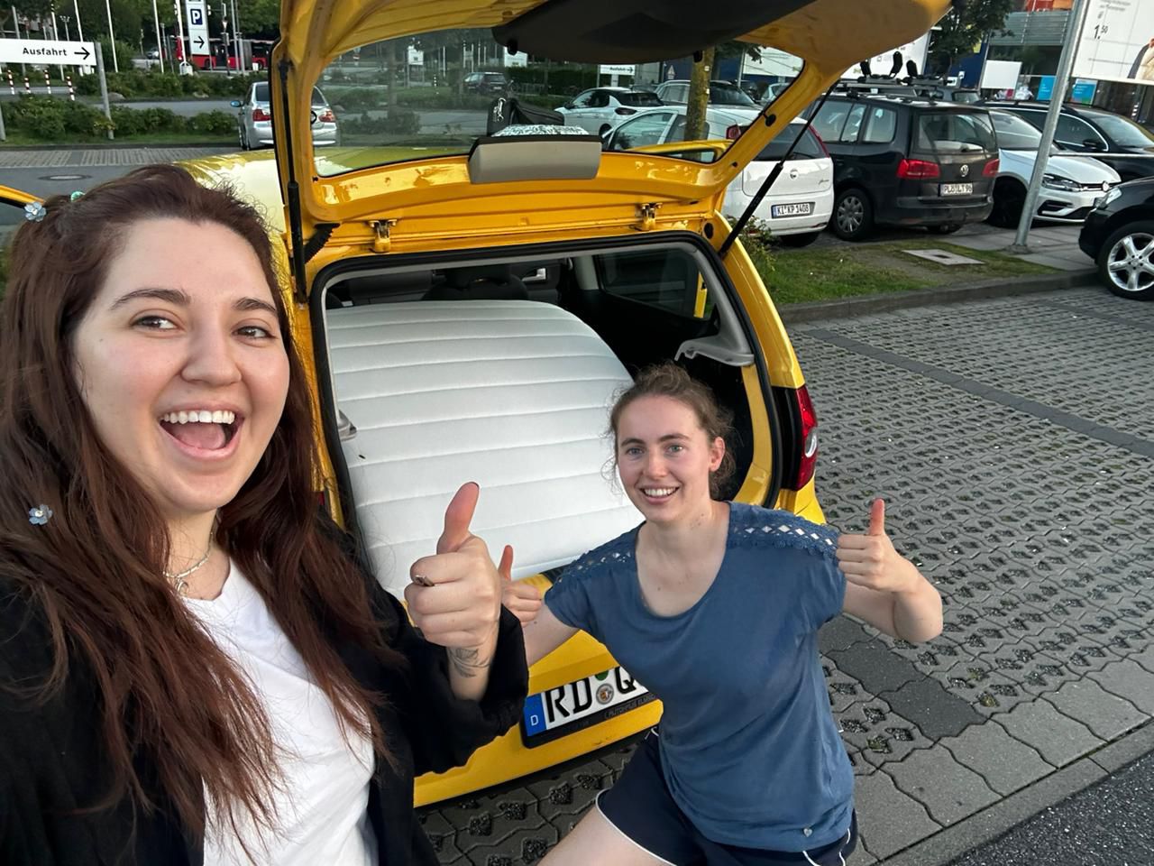 zwei Frauen stehen vor einem Auto