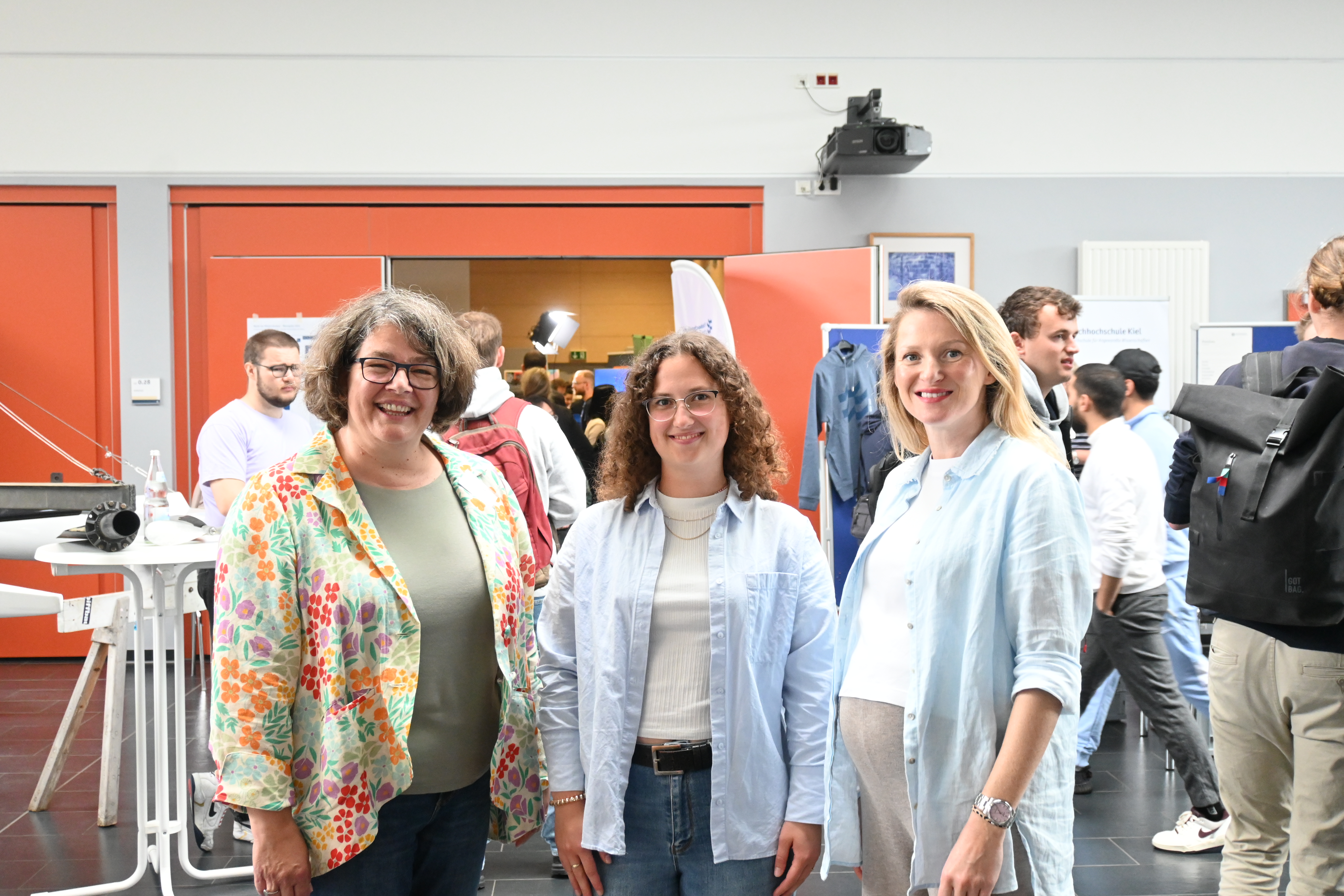 Ruth Boerckel, Nicole Flug und Ekaterina Hameister stehen am Eingang des Audimax der FH Kiel