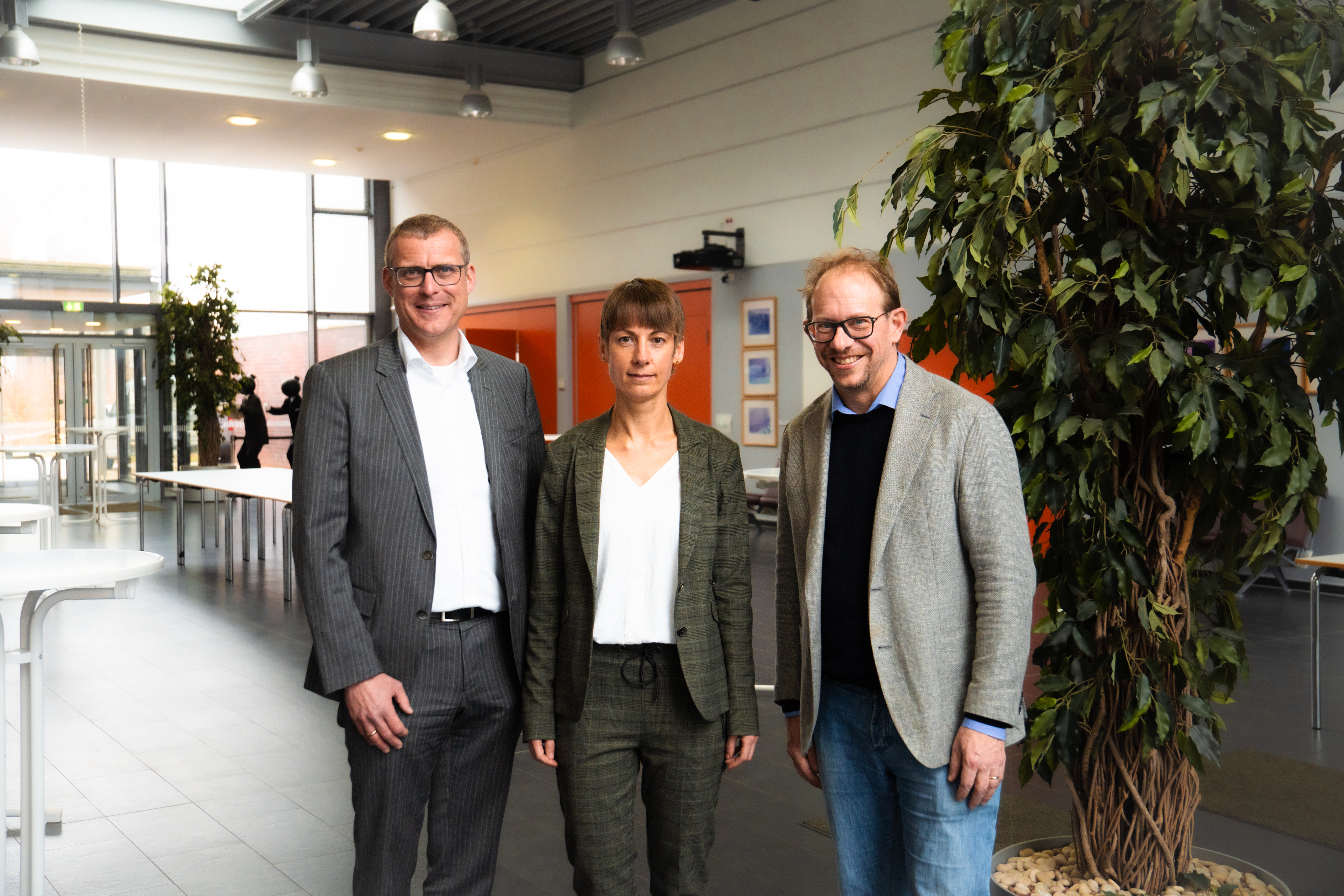 v.l.n.r. FH-Kiel-Präsident Prof. Dr. Björn Christensen, Prof. Dr. Katharina Scheel und Neumünsters Oberbürgermeister Tobias Bergmann im Foyer des Audimax der FH Kiel.